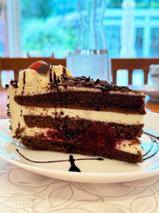 Delicious layered chocolate cake slice with cream and berries
