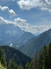 Obraz premium Majestic alpine mountain range under blue sky and fluffy clouds