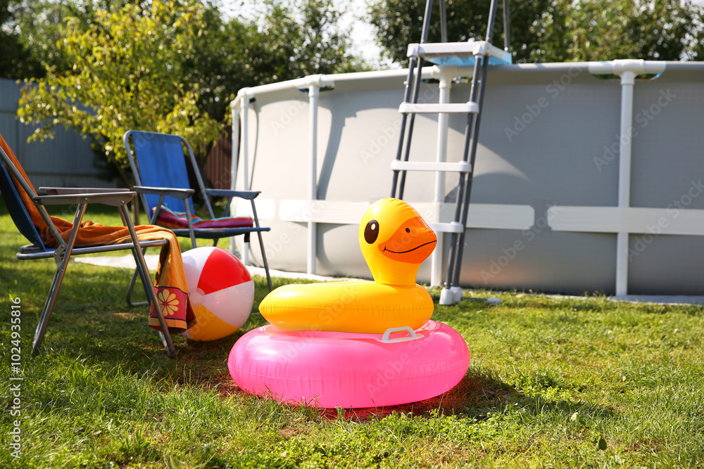 Canvas Prints Above ground swimming pool, folding chairs, towel, inflatable rings and ball in backyard