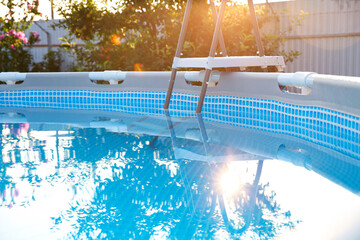 Above ground swimming pool in garden on sunny day, closeup