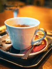 Warm espresso in elegant white cup on rustic wooden café table