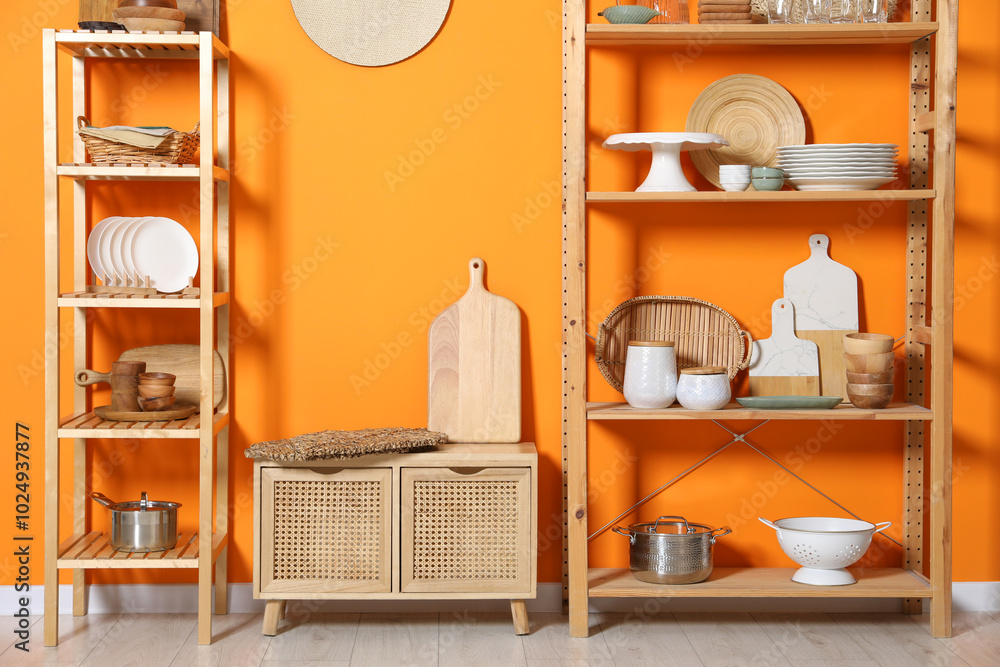 Canvas Prints Wooden storage stands and cabinet with kitchenware near orange wall indoors