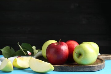 Fresh red and green apples on light blue wooden table