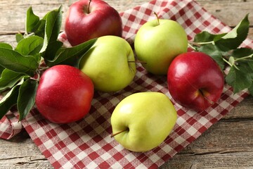 Ripe apples and green leaves on wooden table