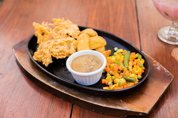 Single beef steak with mushroom sauce that melts in your mouth and is chewy combined with vegetables and French fries.