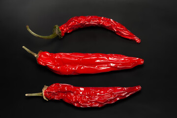 Hot pepper. Chili pepper. Dry red hot pepper stacked on black background. Top view. Selective focus