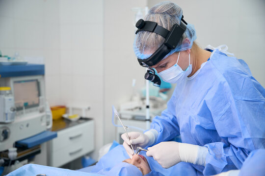 Professional otolaryngologist surgeon performing surgery in modern operating room