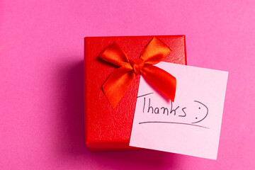 A red box with a red bow and a pink background