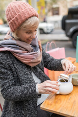 Woman enjoying tea break during winter shopping in city cafe