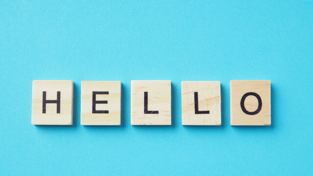 Hello word of wooden letter cubes isolated on blue background.