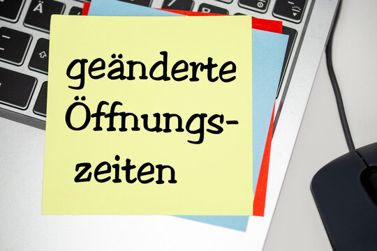 Notizzettel mit der Aufschrift GE&Auml;NDERTE &Ouml;FFNUNGSZEITEN auf einem Laptop
