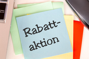 Notizzettel mit der Aufschrift RABATTAKTION auf einem Schreibtisch