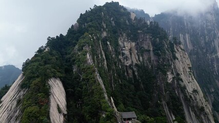 Huashan, China: Aerial drone footage of people climbing up the stairs on the steep ridge of the dramatic Mt Huashan near Xi'an in Shaanxi in central China. - Powered by Adobe