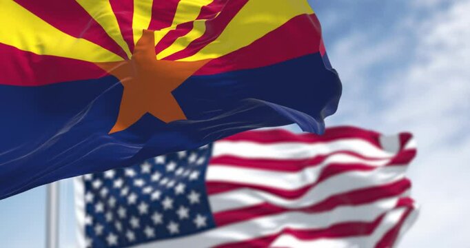 Flags of Arizona and United States waving in the wind on a clear day