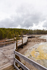 Naklejka premium Scenic Wooden Boardwalk Through Yellowstone National Park in Wyoming, USA on a Cloudy Day