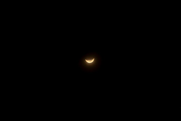 Crescent moon glowing softly against a pitch-black night sky, highlighting the serenity and mystery of the night, a minimalist scene capturing the calmness of the celestial beauty.