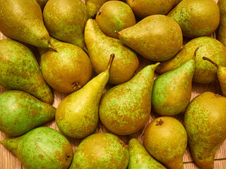 Pile of green pears on wooden table