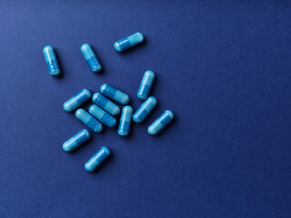 Amino acids capsules on dark paper background. Soft focus.	