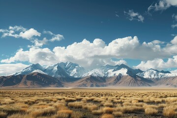 Fototapeta premium Low white clouds floating over dry land of the mountain plateau in Central Asia