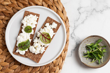 Homemade crispy toasts with ricotta, cottage cheese and herbs, microgreens, healthy eating, food for athletes