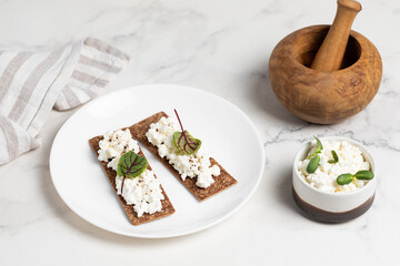 Homemade crispy toasts with ricotta, cottage cheese and herbs, microgreens, healthy eating, food for athletes