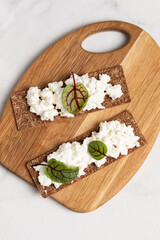 Homemade crispy toasts with ricotta, cottage cheese and herbs, 
microgreens, healthy eating, food for athletes