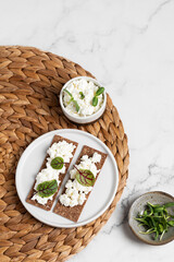 Homemade crispy toasts with ricotta, cottage cheese and herbs, 
microgreens, healthy eating, food for athletes