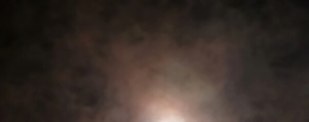 Abstract cosmic scene with soft clouds and glowing light in dark space.