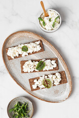 Homemade crispy toasts with ricotta, cottage cheese and herbs, 
microgreens, healthy eating, food for athletes