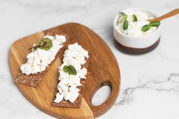Homemade crispy toasts with ricotta, cottage cheese and herbs, 
microgreens, healthy eating, food for athletes