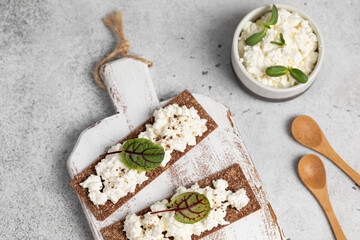 Homemade crispy toasts with ricotta, cottage cheese and herbs, 
microgreens, healthy eating, food for athletes