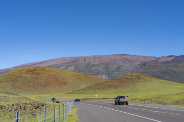 A cinder cone (scoria cone) is a steep conical hill of loose pyroclastic fragments, such as volcanic clinkers, volcanic ash, or scoria that has been built around a volcanic vent. Saddle Road, Hawaii 