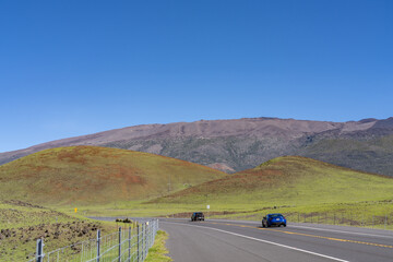 Fototapeta premium A cinder cone (scoria cone) is a steep conical hill of loose pyroclastic fragments, such as volcanic clinkers, volcanic ash, or scoria that has been built around a volcanic vent. Saddle Road, Hawaii 