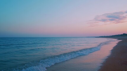Fototapeta premium 美しい夕暮れ時の海岸で、穏やかな波が打ち寄せる風景を楽しむ瞬間