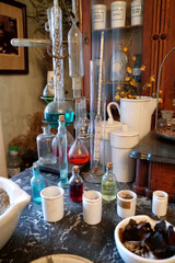 Chemistry flasks with liquids, herbs of medicinal plants in an old pharmacy