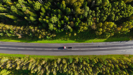 A truck and cars are driving along a beautiful road