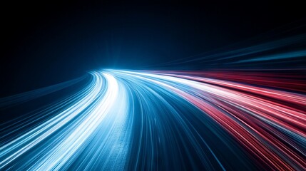 A long exposure shot of a highway with streaking light trails of traffic passing through the city at night. The city skyline glows brightly in the distance.