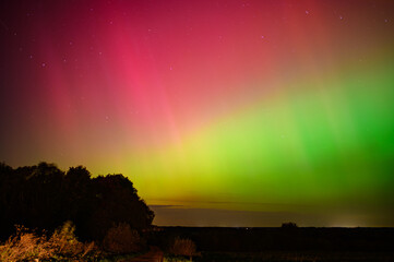 Stunning aurora borealis lights up the night sky with vibrant colors, creating a mesmerizing natural display in the Lithuania fields 10 11 2024