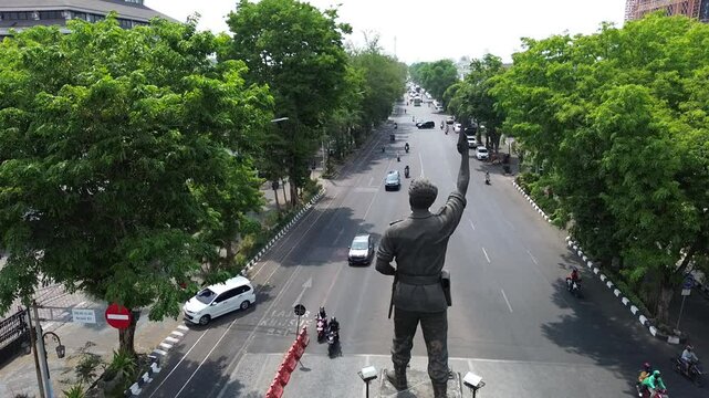 The atmosphere of Surakarta's Slamet Riyadi street and the monument statue is visible, aerial drone, footage city, Indonesia