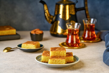 Middle eastern traditional semolina cake basbousa , namoora, hareesa served with tea 