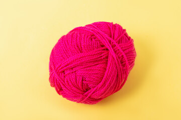 Crimson yarn for knitting on yellow background