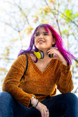 Plus size autistic girl with pink hair smiling happily in the city.