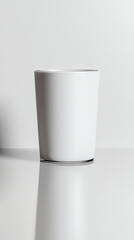 White ceramic cup on a reflective surface.