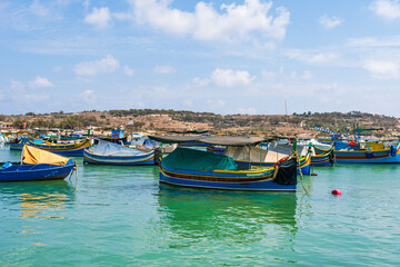 Obraz premium View of Marsaxlokk harbour with traditional colourful fishing boats in Malta