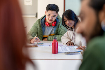 Fototapeta premium Asian students studying together, diverse friends collaborating on university project with smartphone