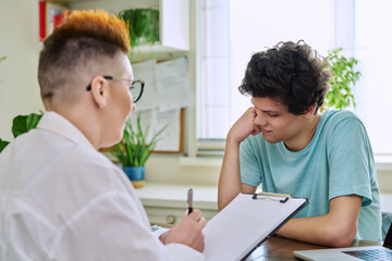 Fototapeta premium College student guy at meeting with professional counselor, social worker