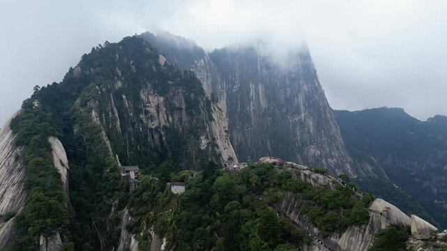 Huashan, China: Aerial drone footage of the ridge of the dramatic Mt Huashan near Xi'an in Shaanxi in central China with atmospheric mist and fog. 