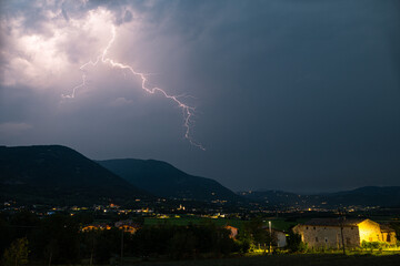 Whimsical lightning over the landscape of the southern limestone Alps near Lake Garda in Italy