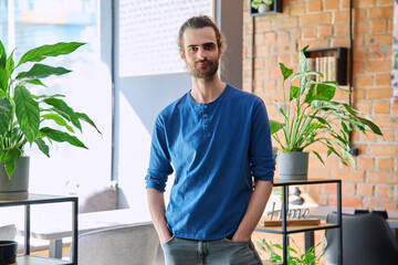 Portrait of young confident handsome man looking at camera