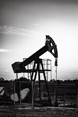 The central element is the pumpjack, a distinctive piece of machinery used to extract oil from underground reservoirs. Its intricate structure, with its counterbalanced beam.